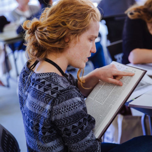 Maia in profile doing text study in a classroom